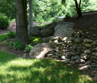 dry stack field stone wall sloped landscape bed